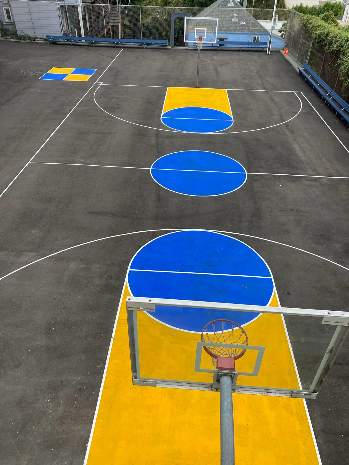 After: church school basketball court painted with blue, yellow, and white line striping