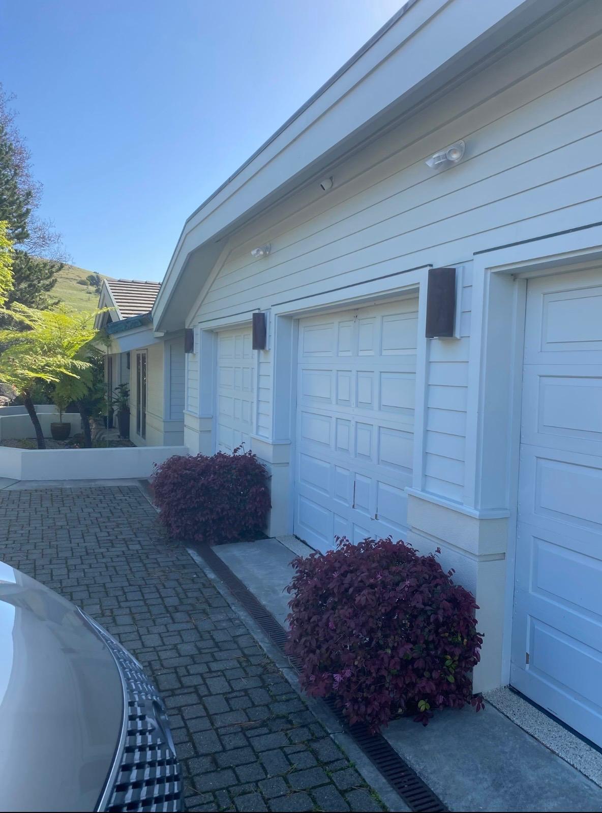 Finished residential garage exterior painted in clean white and soft gray